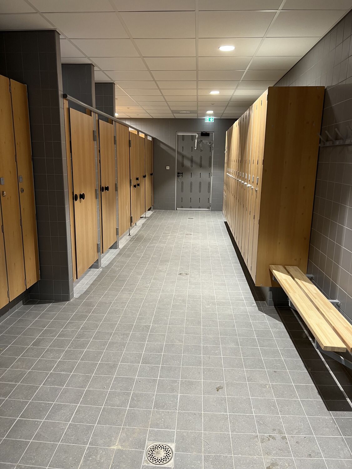 Vestiaire en compact stratifié : cabines, casiers décor bois et banc