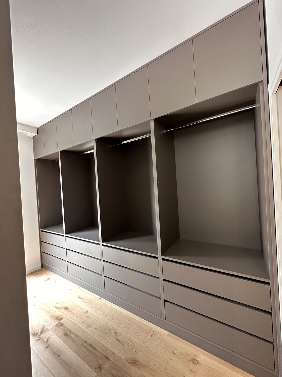 Dressing sur mesure en finition taupe avec penderies, tiroirs et niches